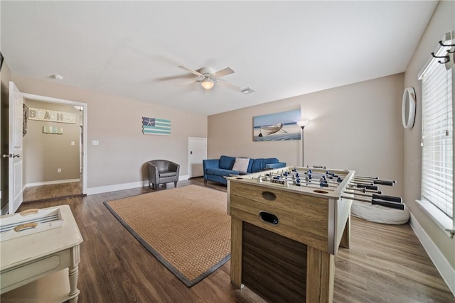 game room with dark wood-type flooring and ceiling fan