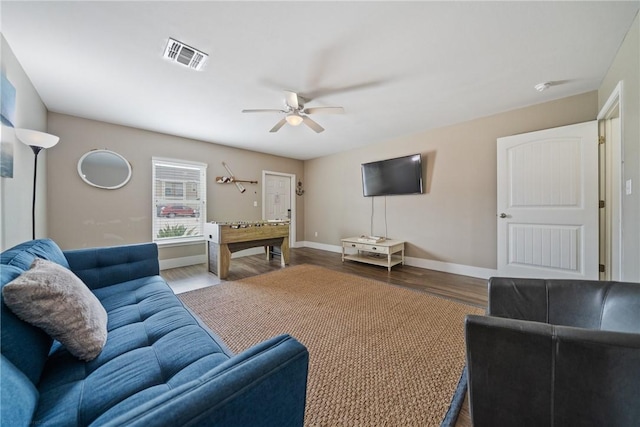 living room featuring dark wood-type flooring and ceiling fan