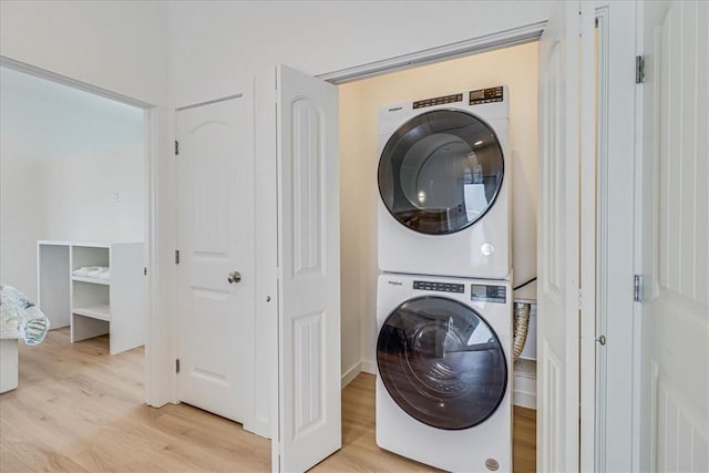 clothes washing area with stacked washer and dryer and light hardwood / wood-style flooring