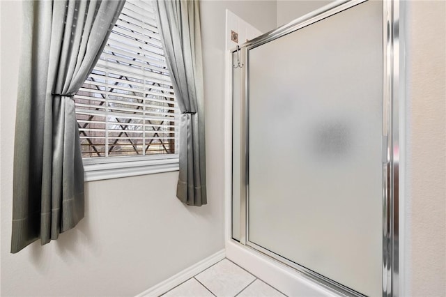 bathroom featuring a shower stall, baseboards, and tile patterned floors