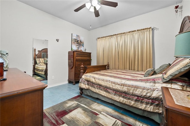 tiled bedroom with a ceiling fan and baseboards