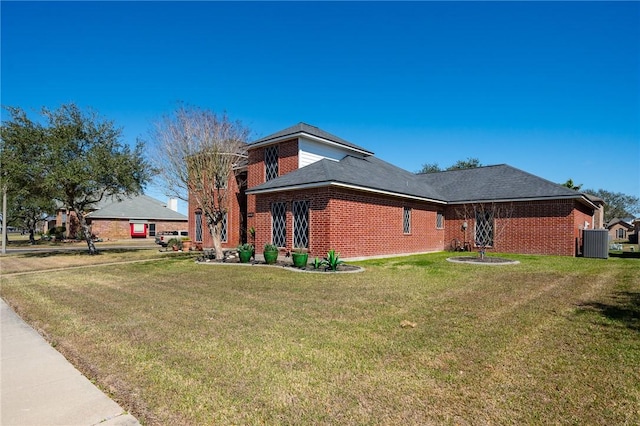 view of side of property featuring central AC unit, a lawn, and brick siding