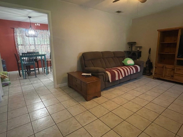 living room with ceiling fan with notable chandelier and light tile patterned floors