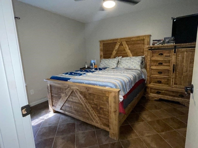 bedroom featuring ceiling fan and dark tile patterned floors