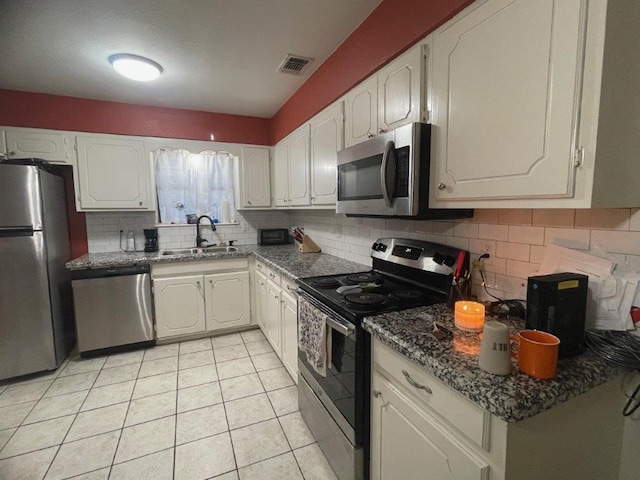 kitchen with stainless steel appliances, white cabinetry, sink, and tasteful backsplash