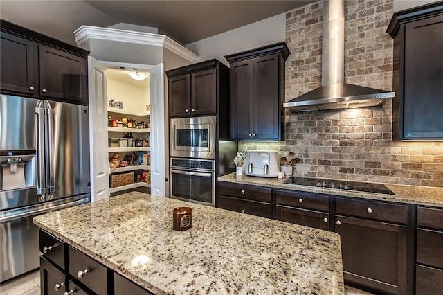 kitchen with stainless steel appliances, light stone counters, and wall chimney exhaust hood