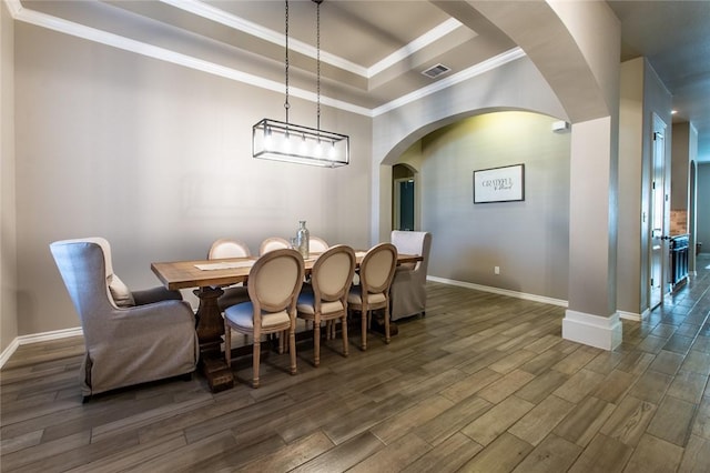 dining area featuring a raised ceiling and crown molding