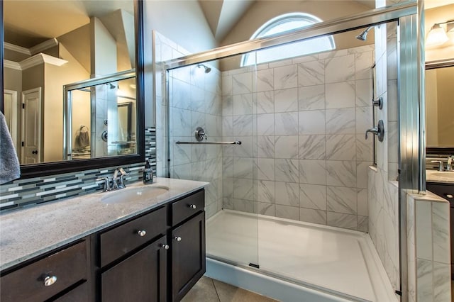 bathroom featuring tasteful backsplash, lofted ceiling, tile patterned flooring, vanity, and an enclosed shower