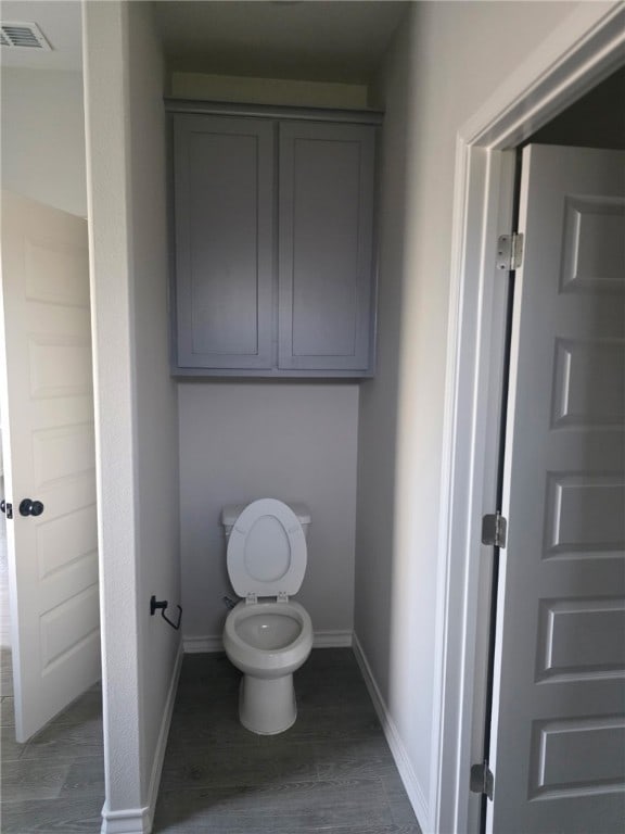 714 Mereet Dr, Corpus Christi, TX 78418 - bathroom with baseboards, wood finished floors, visible vents, and toilet