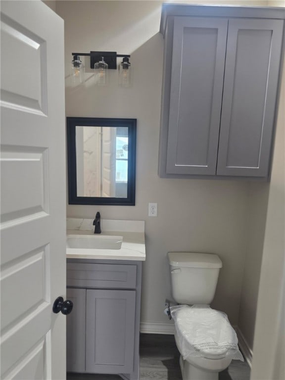 714 Mereet Dr, Corpus Christi, TX 78418 - bathroom with baseboards, vanity, toilet, and wood finished floors