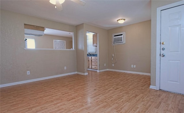 1005 Ronald Dr, Corpus Christi, TX 78412 - spare room with ceiling fan, light wood-style flooring, a wall mounted air conditioner, and baseboards
