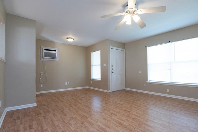 1005 Ronald Dr, Corpus Christi, TX 78412 - empty room with a wall unit AC, light wood-style flooring, baseboards, and ceiling fan