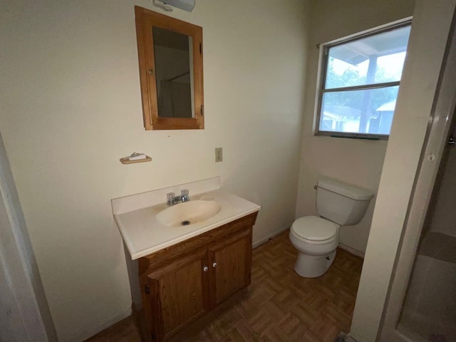 bathroom featuring vanity, parquet floors, and toilet