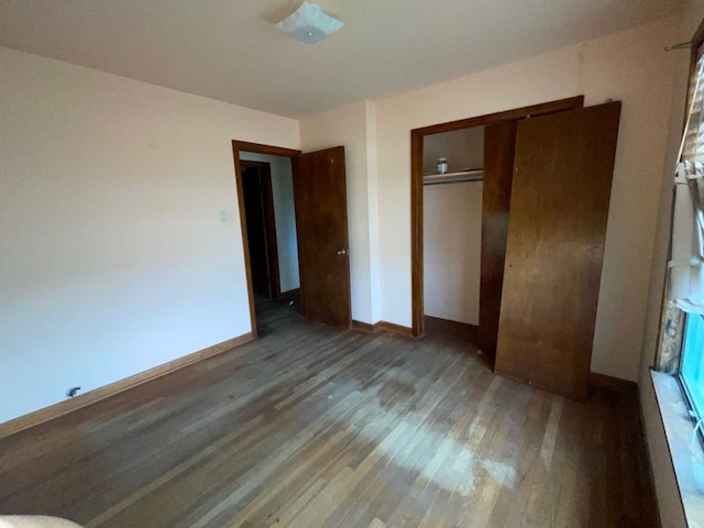 unfurnished bedroom with a closet and dark hardwood / wood-style floors