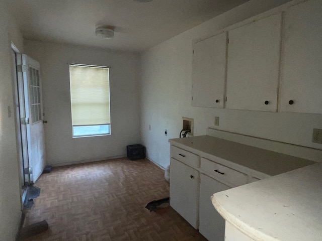 kitchen with white cabinets and dark parquet flooring