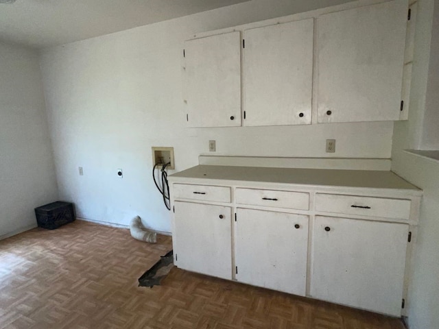 washroom with dark parquet floors, cabinets, washer hookup, and hookup for an electric dryer