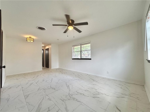empty room featuring baseboards, ceiling fan, marble finish floor, and visible vents