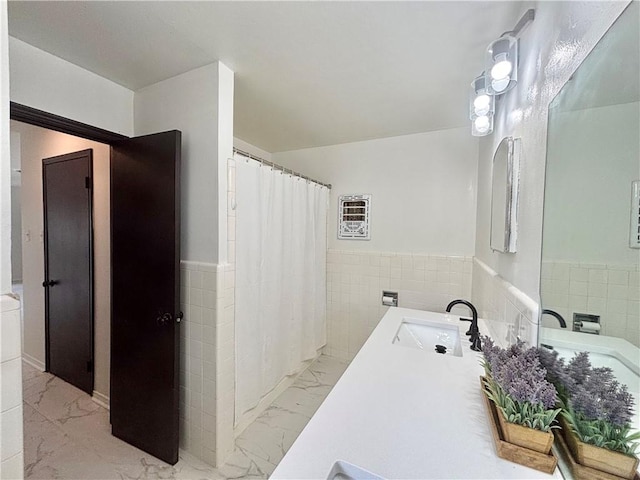 full bath featuring wainscoting, vanity, marble finish floor, tile walls, and a shower with curtain