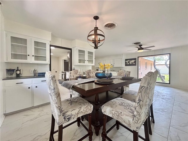 dining room featuring visible vents, marble finish floor, and ceiling fan with notable chandelier