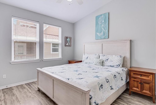 bedroom with a ceiling fan, baseboards, and light wood finished floors