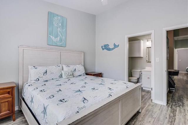 bedroom featuring ensuite bath, baseboards, and wood finished floors