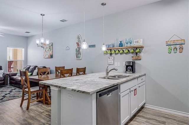 kitchen with visible vents, stainless steel dishwasher, white cabinetry, a sink, and wood finished floors