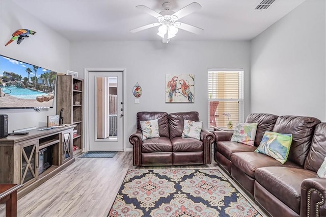 living area with ceiling fan, wood finished floors, and visible vents