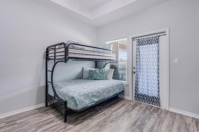 bedroom with baseboards and wood finished floors