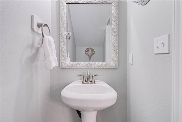 bathroom with a textured wall and a sink