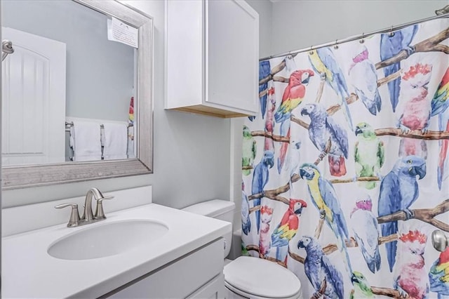 bathroom with a shower with curtain, vanity, and toilet