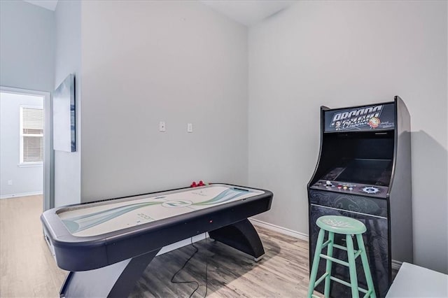 recreation room featuring baseboards and wood finished floors