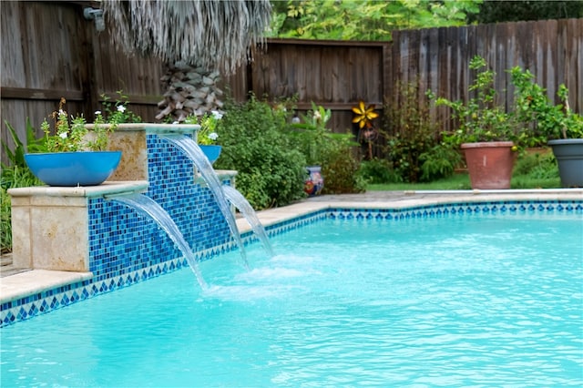 view of swimming pool with pool water feature