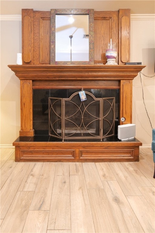 room details with a fireplace, wood-type flooring, and crown molding