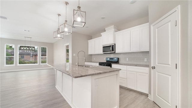 3634 Rebecca Dr, Corpus Christi, TX 78410 - kitchen featuring black gas range oven, a sink, stainless steel microwave, light wood-style flooring, and tasteful backsplash