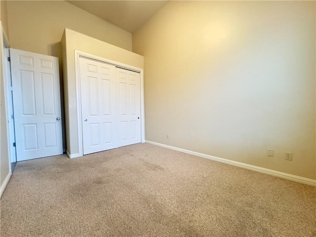 unfurnished bedroom featuring light carpet and a closet