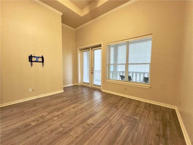 unfurnished room featuring wood-type flooring, french doors, ornamental molding, and a healthy amount of sunlight