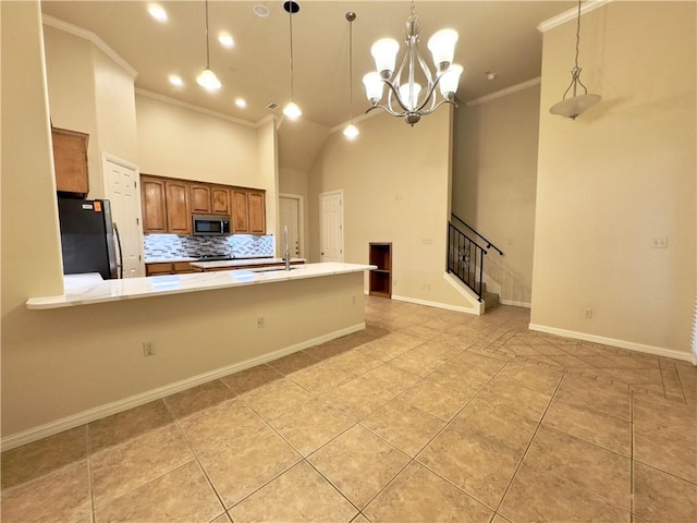 kitchen featuring sink, a notable chandelier, crown molding, pendant lighting, and appliances with stainless steel finishes