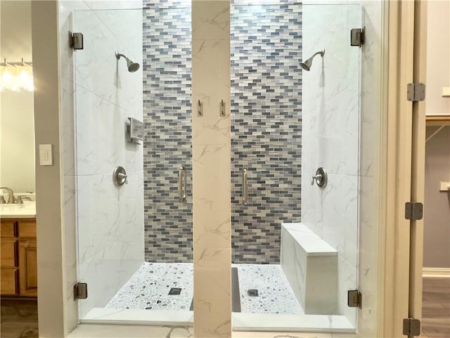 bathroom with a shower with door, vanity, and hardwood / wood-style flooring