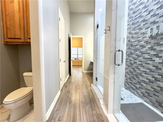 bathroom featuring hardwood / wood-style floors, toilet, and walk in shower