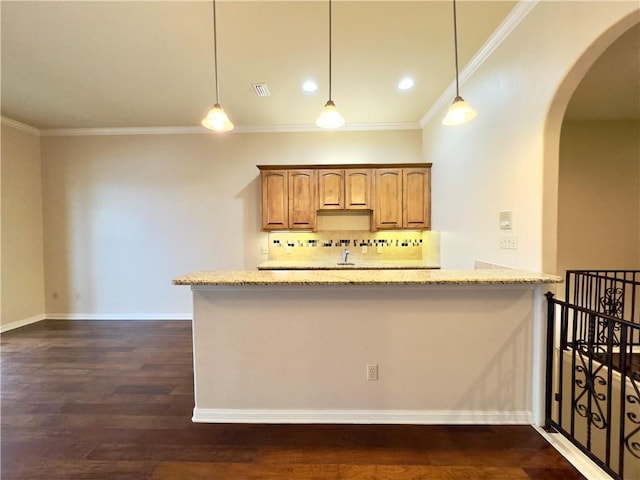 kitchen featuring decorative light fixtures, dark hardwood / wood-style flooring, light stone countertops, and decorative backsplash