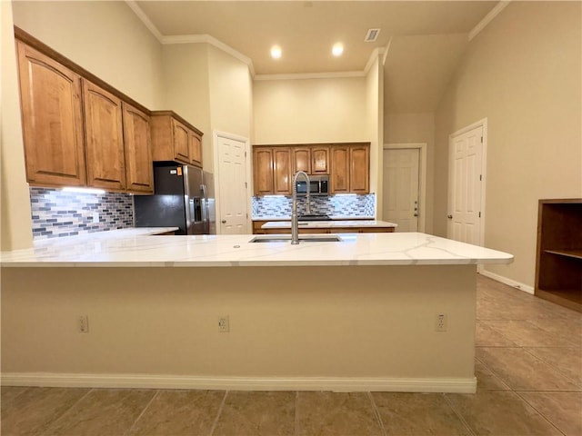 kitchen featuring tasteful backsplash, kitchen peninsula, crown molding, and stainless steel appliances