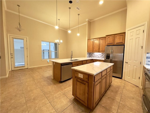 kitchen featuring kitchen peninsula, appliances with stainless steel finishes, sink, a center island, and hanging light fixtures