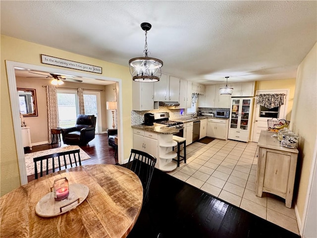 dining room featuring a textured ceiling, ceiling fan, light tile patterned flooring, and baseboards