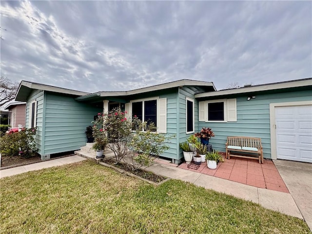 single story home with a garage and a front lawn