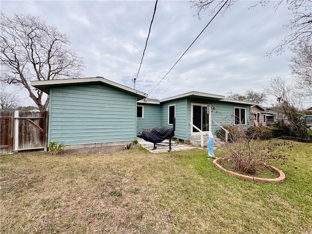 rear view of house featuring a yard and fence