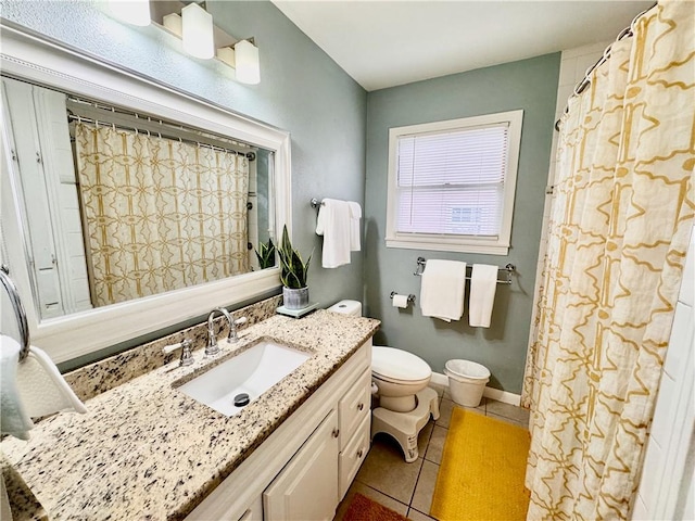 bathroom with toilet, vanity, baseboards, and tile patterned floors