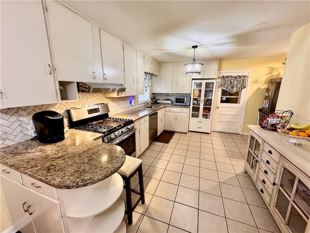 kitchen featuring light tile patterned floors, under cabinet range hood, white cabinetry, appliances with stainless steel finishes, and decorative backsplash