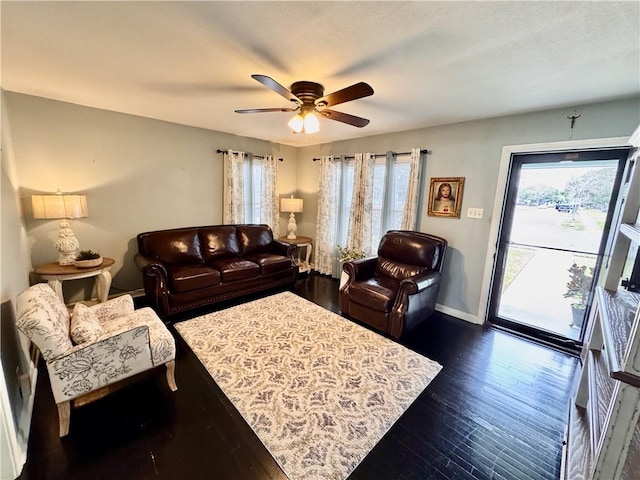 living room featuring ceiling fan, dark wood-style flooring, and baseboards