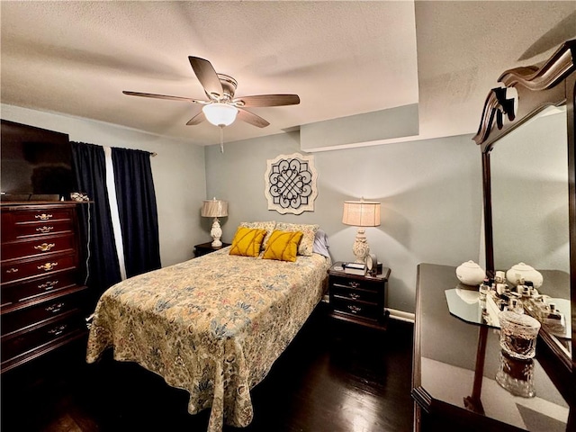 bedroom with dark wood-style floors, a textured ceiling, and a ceiling fan