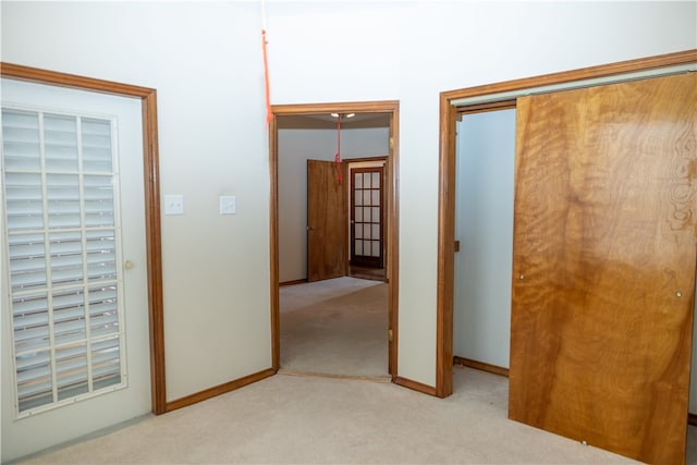 unfurnished bedroom with light colored carpet and a closet